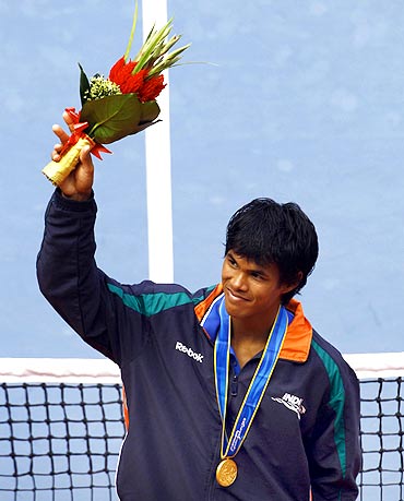 India's Somdev Devvarman celebrates with his gold medal after his men's tennis final win over Uzbekistan's Denis Istomin at the 16th Asian Games in Guangzhou