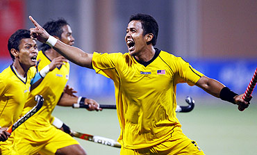 Malaysia's Muhamad Amin Rahim celebrates after scoring the winning goal against India in their men's semi-final field hockey game at the 16th Asian Games in Guangzhou