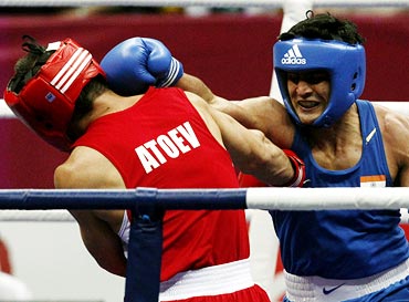 Vijender Singh (right) lands a punch on Abbos Atoev of Uzbekistan