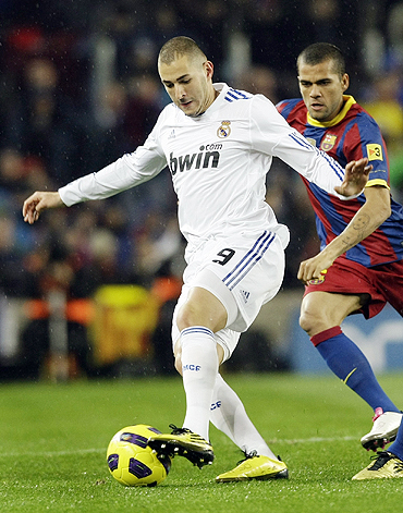 Real Madrid's Karim Benzema (left) and Barcelona's Dani Alves vie for possession