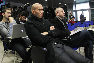 Real Madrid's first team adviser Zinedine Zidane listens to Jose Mourinho at a news conference
