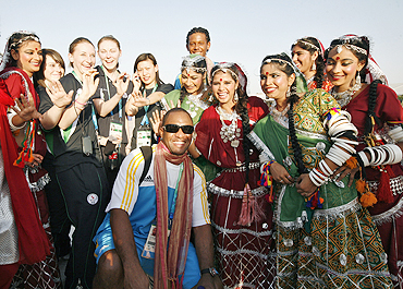 New Zealand athletes pose with Indian performers on their arrival in the Games Village