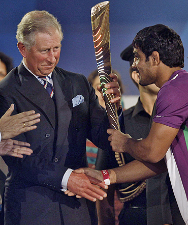 Britain's Prince Charles (left) receives the Queen's Baton from Indian wrestler Sushil Kumar during the opening ceremony