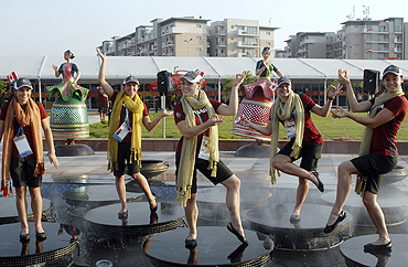 Members from the Canadian team pose at a water fountain at the Game Village