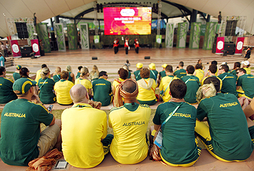 Australian team members watch the team's flag-raising ceremony at the Commonwealth Games Village in Delhi