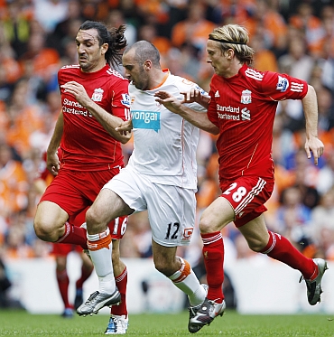 Liverpool's Kyrgiakos and Poulsen chase Blackpool's Taylor-Fletcher during their English Premier League