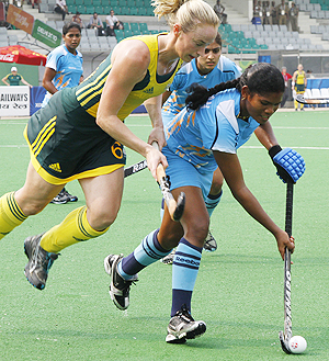 India's Subhadra Pradhan (right) goes past Australia's Megan Rivers during their hockey group match on Wednesday