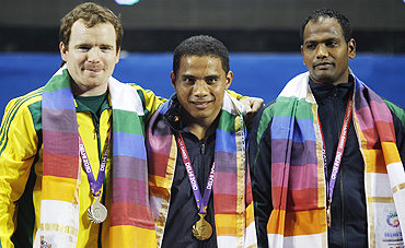 Gold medallist Peter Yukio (centre) of Nauru poses with silver medallist Ben Turner (left) of Australia and bronze medallist Raju Sudhir Kumar of India after winning the men's 77kg weightlifting competition on Thursday