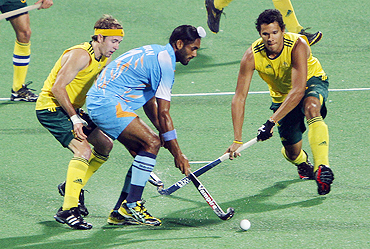 India's Saravanjit Singh (centre) is challenged by Australia's Joel Carroll (right) and Matthew Swann during their hockey group match on Thursday