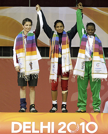 Gold medallist Alka Tomar of India (centre), silver medallist Tonya Verbeek (left) of Canada and bronze medallist Tega Tosin Richard of Nigeria pose on the podium after their 59kg women's freestyle wrestling event on Friday