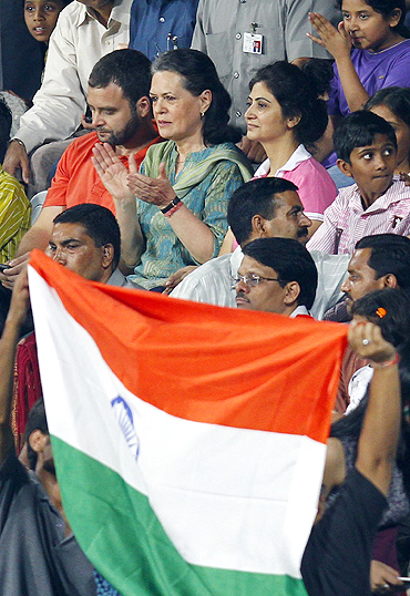 Congress party president Sonia Gandhi and her son Rahul Gandhi (top left) applaud after India's win over Pakistan at the men's hockey group match on Sunday