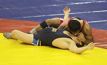 India's Sushil Kumar (red) challenges South Africa's Heinrich Barnes during their 66kg men's freestyle wrestling match on Sunday
