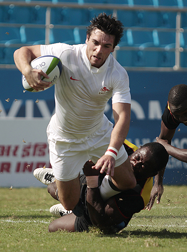 Uganda's Robert Sseguya fails to prevent England's Mathew Turner from scoring during their rugby sevens pool match on Monday