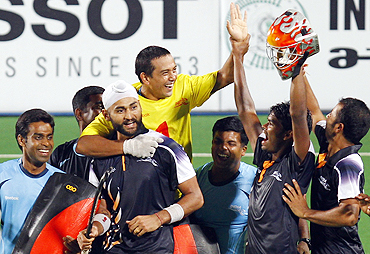 Indian hockey players celebrate after securing a place in the final by beating England in a penalty shootout on Tuesday