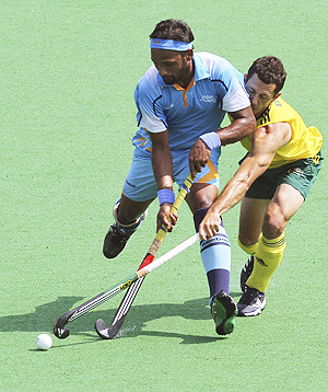 India's Dhananjay Mahadik (L) fights for the ball with Australia's Jamie Dwyer