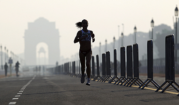 Michelle Cope of England runs past India Gate while competing in the women's marathon final on Thursday