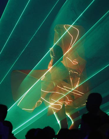 A dancer, illuminated by lasers, performs at the Jawaharlal Nehru stadium