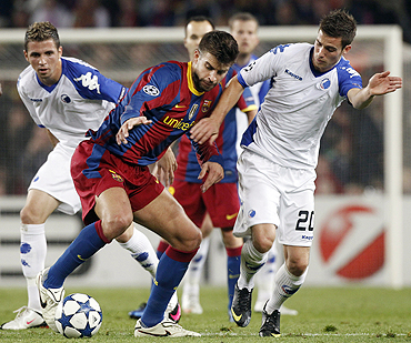 Barcelona's Gerard Pique (centre) vies for possession with FC Copenhagen's Martin Vingaard and Claudemir (left)