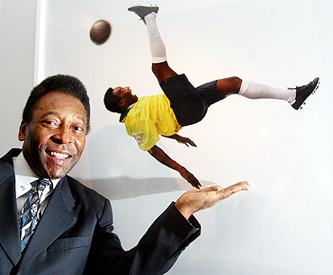 Pele stands next to a photograph of him at a photo exhibition