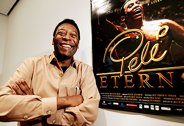 Pele poses next to a poster of documentary film 'Pele Forever' at New York's Museum of Modern Art
