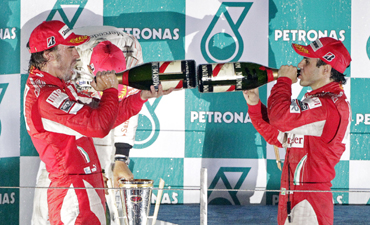 Ferrari Formula One driver Fernando Alonso of Spain (L) and his teammate Felipe Massa of Brazil spray champagne as they celebrate on the podium after Alonso won the South Korean F1 Grand Prix