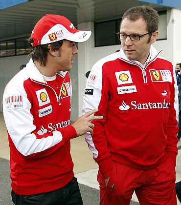 Ferrari's Fernando Alonso talks with team principal Stefano Domenicali in the paddock area