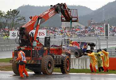 A crane lifts the car of Red Bull driver Mark Webber after he crashed out of the South Korean F1 Grand Prix