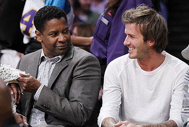Actor Denzel Washington (left) and English footballer star David Beckham chat during the NBA game in Los Angeles, California, on Tuesday