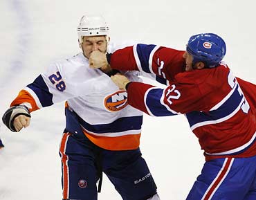 Montreal Canadiens' Travis Moen (right) lands a punch on Zenon Konopka of New York Islanders as they fight during the second period