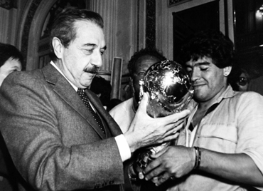 Diego Maradona (R), captain for the 1986 World Cup-winning  squad, hands the trophy to then Argentine President Raul Alfonsin in Buenos Aires