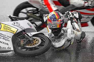 Honda 125 cc rider Marcel Schrotter of Germany falls during the second free practice session of the Portuguese Grand Prix in Estoril