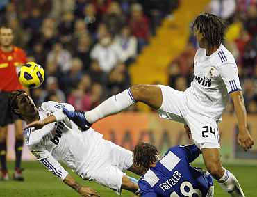 Real Madrid's Esteban Granero (R) kicks the ball past Hercules' Matias Fritzler