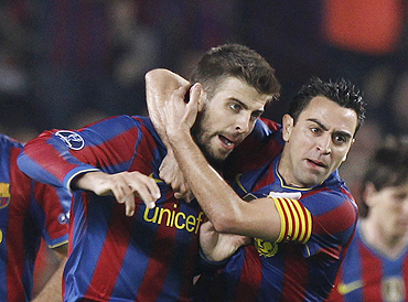 Barcelona's Xavi (right) and teammate Gerrard Pique