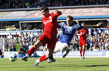 Birmingham City's Roger Johnson (right) challenges Liverpool's Fernando Torres