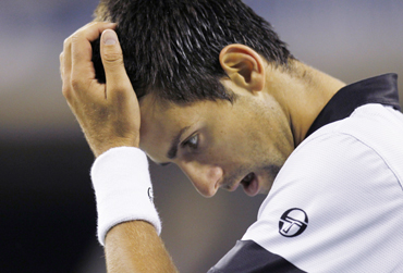 Novak Djokovic of Serbia reacts to losing a point during his match against Rafael Nadal of Spain