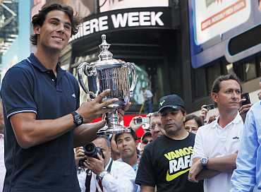 Rafael Nadal of Spain, winner of the 2010 US Open, poses with the trophy at Times Square in New York