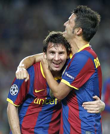 Lionel Messi celebrates with David Villa after scoring a goal
