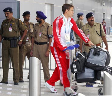 A member from England's team walks past Indian security personnel at the Delhi airport