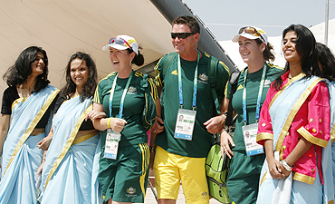 Australian athletes Lynsey Aromitage (3rd from left), Leif Selby (centre) and Claire Duke pose with Indian folk dancers at the Games village in New Delhi