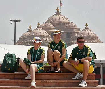 Australian athletes sit in front of the 'Akshardham temple at the Commonwealth Games athletes village