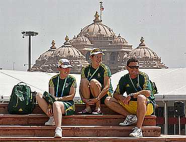 Australian athletes sit in front of the Akshardham temple at the Commonwealth Games athletes village