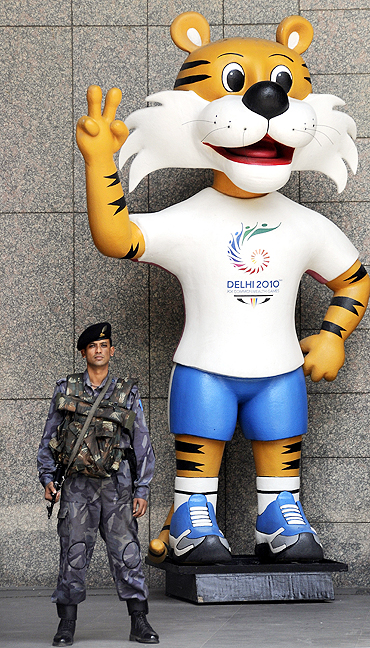 A security personnel stands guard besides the mascot of the 2010 Commonwealth Games in New Delhi