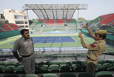 Indian policemen chat inside the RK Khanna Tennis stadium in New Delhi