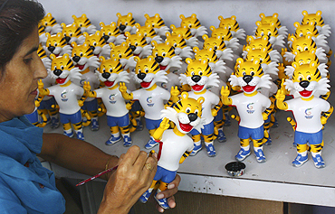 An artisan paints a model of the mascot of the Commonwealth Games inside a factory in Mohali