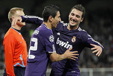 Real Madrid's Angel Di Maria celebrates with teammate Higuain after scoring against Auxerre