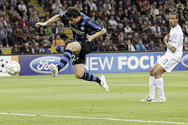 Inter Milan's Diego Milito (left) shoots and scores as Joel Matip of Schalke looks on