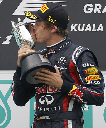 Red Bull's Sebastian Vettel kisses the winner's trophy after the Malaysian GP