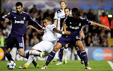 Tottenham's Tom Huddlestone is marked by Raul Albiol and Samir Khedira of Real Madrid