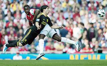 Arsenal's Johan Djourou (left) challenges Liverpool's Luis Suarez