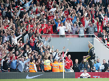 Liverpool's Dirk Kuyt celebrates in front of the Liverpool fans after scoring a penalty against Arsenal